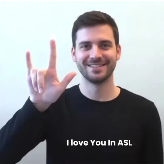 Man signing I Love You in American Sign Language with pinky, index finger, and thumb extended